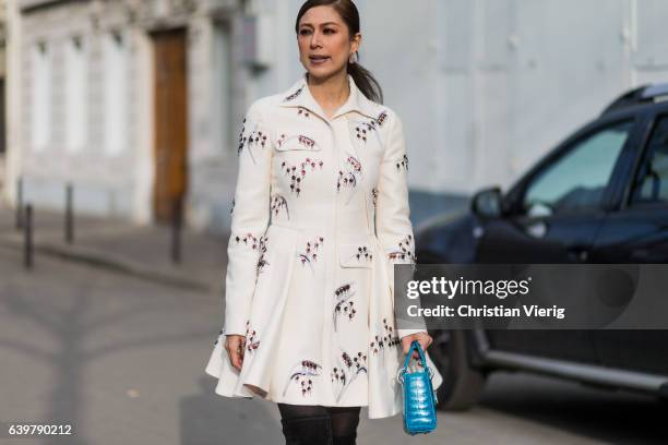 Guest wearing a white Dior jacket and bag outside Dior on January 23, 2017 in Paris, Canada.