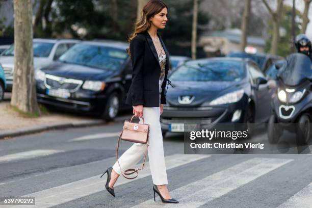 Negin Mirsalehi wearing Dior blazer, white pants, heels and bag outside Dior on January 23, 2017 in Paris, Canada.