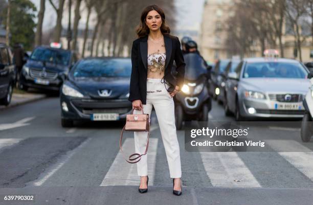 Negin Mirsalehi wearing Dior blazer, white pants, heels and bag outside Dior on January 23, 2017 in Paris, Canada.
