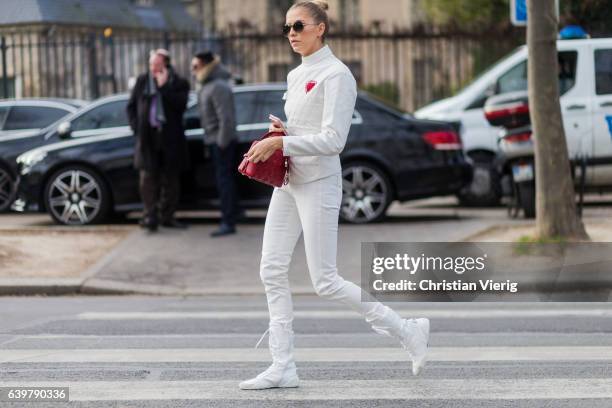 Elena Perminova wearing a white jacket and white pants and red Dior bag outside Dior on January 23, 2017 in Paris, Canada.