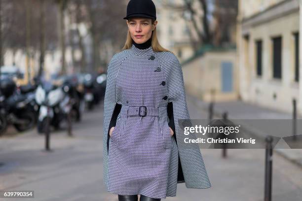 Russain model Natalia Vodianova wearing a flat hat and a checked cape outside Dior on January 23, 2017 in Paris, Canada.