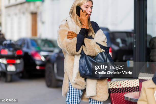 Camille Charriere wearing a teddy coat, brown leather gloves checked pants outside Dior on January 23, 2017 in Paris, Canada.