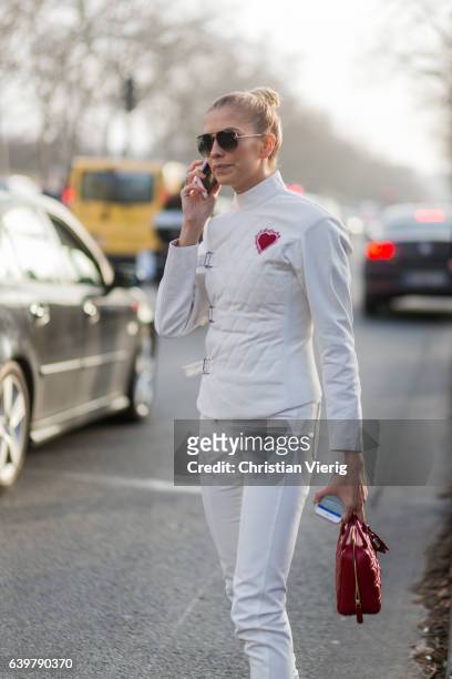 Elena Perminova wearing a white jacket and white pants and red Dior bag outside Dior on January 23, 2017 in Paris, Canada.