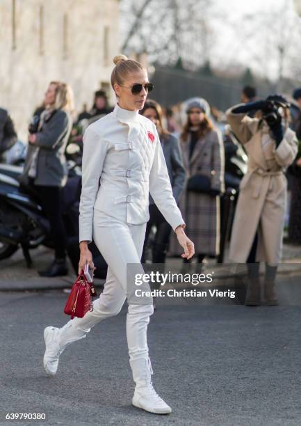 Elena Perminova wearing a white jacket and white pants and red Dior bag outside Dior on January 23, 2017 in Paris, Canada.