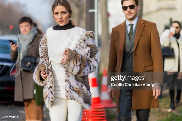 Oliva Palermo wearing a fur jacket and white knit and cropped pants and Johannes Huebel outside Dior on January 23, 2017 in Paris, Canada.
