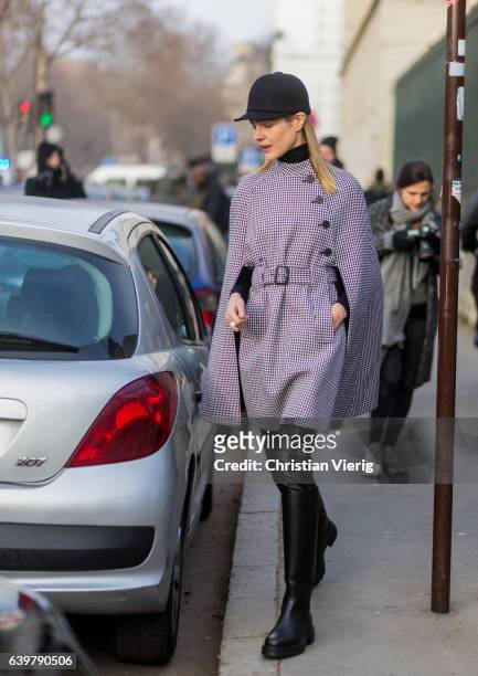 Russain model Natalia Vodianova wearing a flat hat and a checked cape outside Dior on January 23, 2017 in Paris, Canada.