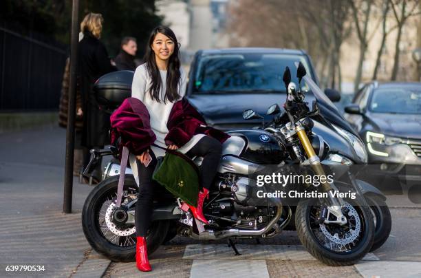 Yuwei Zhangzou sitting on a motor bike wearing a white knit outside Dior on January 23, 2017 in Paris, Canada.