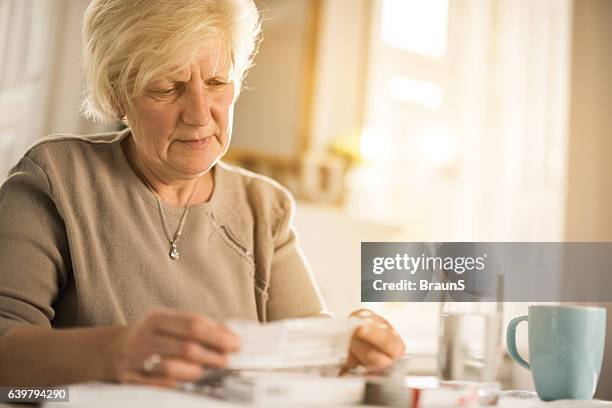 old woman reading instructions for a medicine. - instructions stockfoto's en -beelden