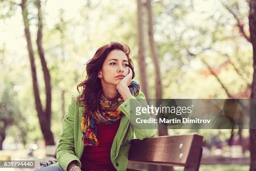 Unhappy girl sitting at bench