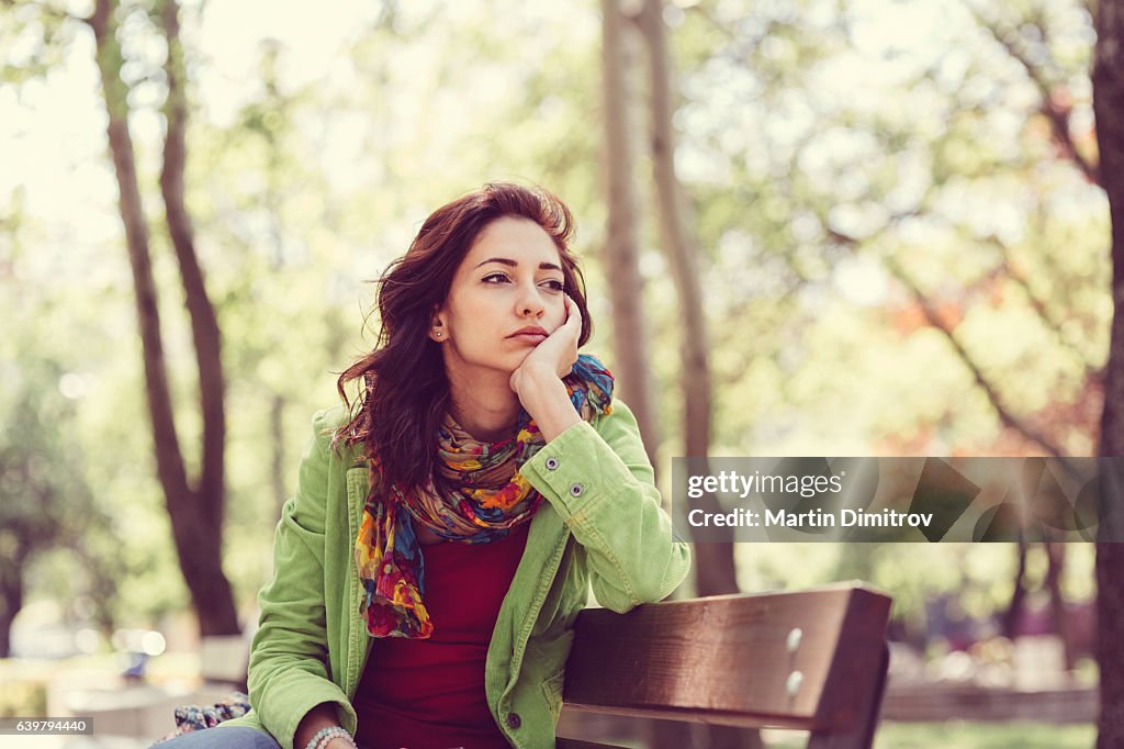 Unhappy girl sitting at bench