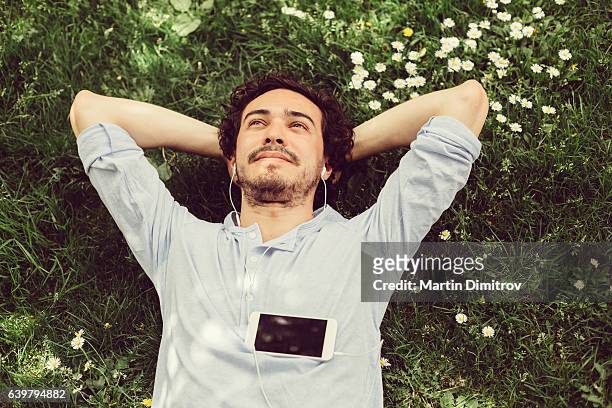 uomo sognante nell'erba - ambientazione tranquilla foto e immagini stock