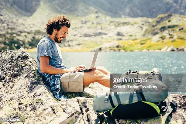 man using a laptop in the mountain - time off work stock pictures, royalty-free photos & images