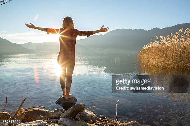 giovane donna che abbraccia la natura, il lago di montagna - vivere semplicemente foto e immagini stock