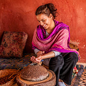 Moroccan woman producing argan oil by traditional methods