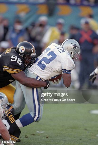 Emmitt Smith of the Dallas Cowboys gets tackled by Brentson Buckner of the Pittsburgh Steelers during Super Bowl XXX on January 28, 1996 at Sun Devil...