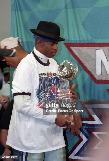 Deion Sanders of the Dallas Cowboys celebrates standing with the Lombardi Trophy after they defeated the Pittsburgh Steelers in Super Bowl XXX on...