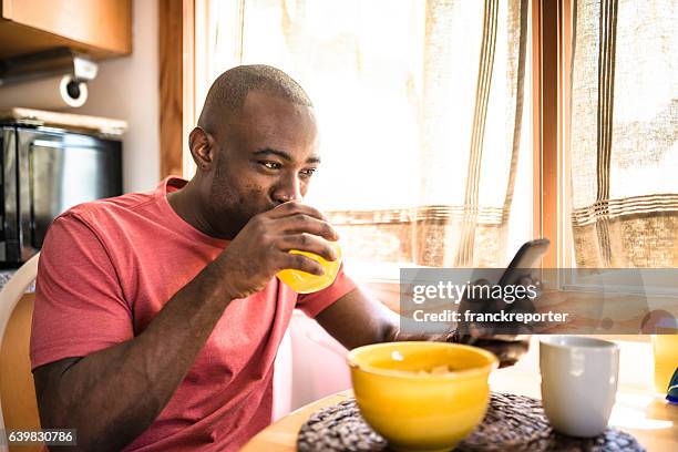 african guy doing breakfast at home - work video call stock pictures, royalty-free photos & images