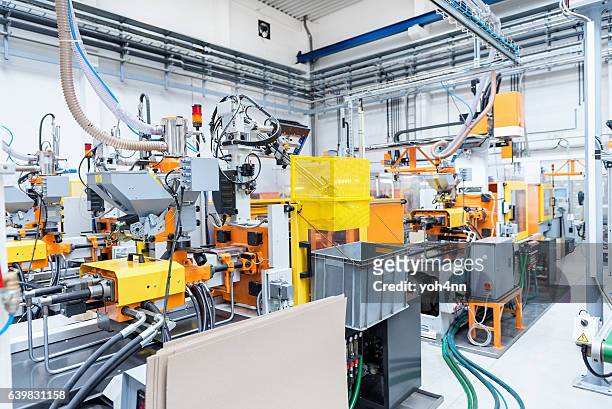 macchine per stampaggio a iniezione all'interno della fabbrica di plastica - polimero foto e immagini stock