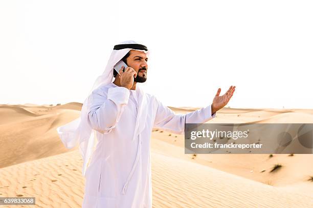arabic sheik on the phone on the desert - middle eastern male on phone isolated stock pictures, royalty-free photos & images