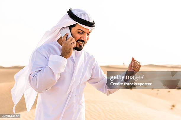 arabic sheik on the phone on the desert - middle eastern male on phone isolated stock pictures, royalty-free photos & images