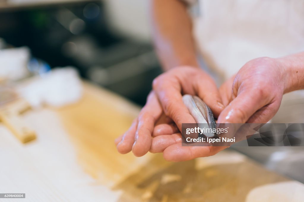 Sushi chef making artisanal nigiri-zushi at bar, Tsukiji, Tokyo