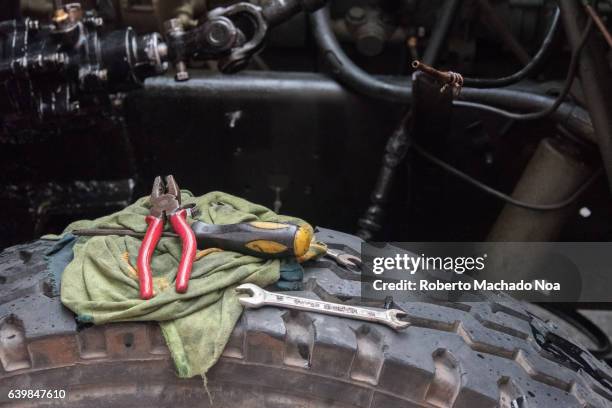 cuban lifestyle: tools of mechanic over wheel in diesel truck being repaired in the street - truck repair stock pictures, royalty-free photos & images