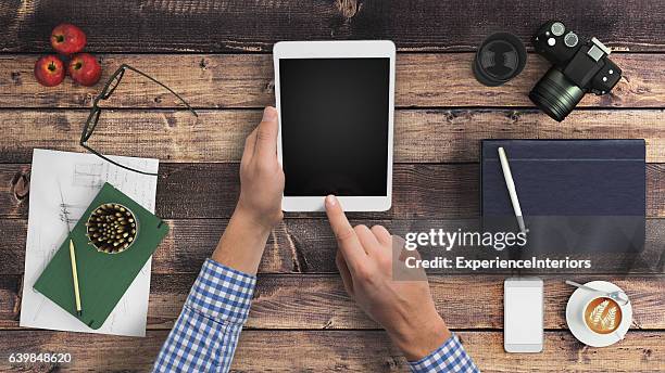 man hipster holding tablet knolling overhead view - desk tablet phone monitor stock pictures, royalty-free photos & images