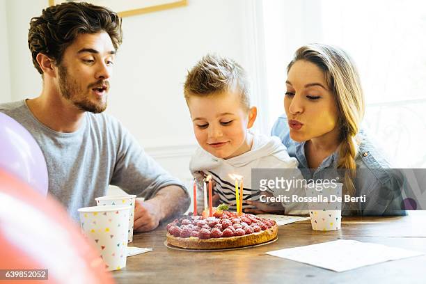 home party with family for little boy's birthday - blowing out candles pov stock pictures, royalty-free photos & images