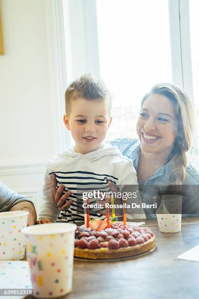 zu hause mit familie feiern geburtstag für kleine jungen - blowing out candles pov stock-fotos und bilder