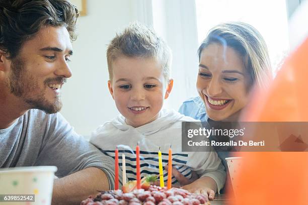 zu hause mit familie feiern geburtstag für kleine jungen - blowing out candles pov stock-fotos und bilder