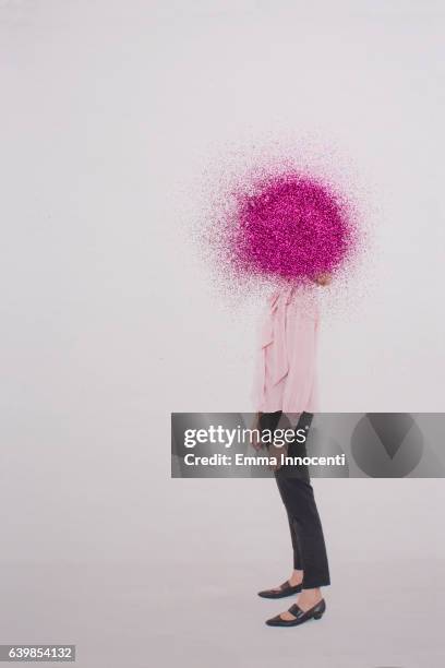 mature woman with head covered by pink ball - odd one out obscure stock-fotos und bilder