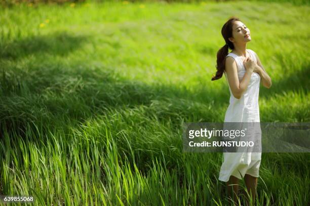 woman enjoying nature - 胸に手を当てる ストックフォトと画像