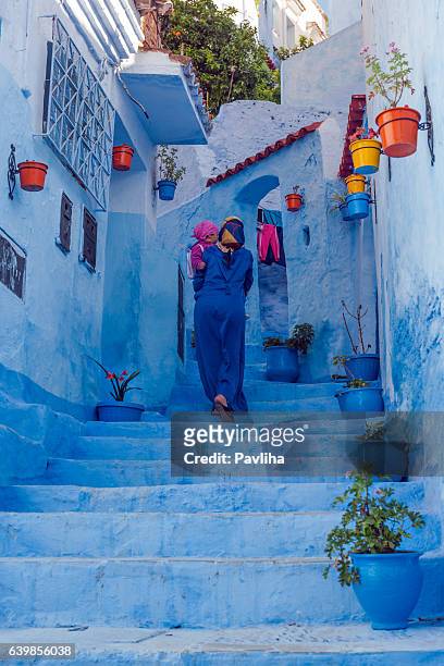 woman in blue djellaba and child in blue city, morocco - moroccan girls bildbanksfoton och bilder