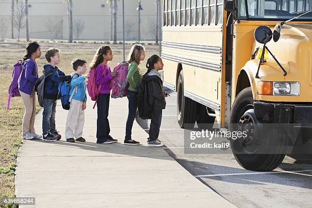 children boarding school bus - kids in a row stock pictures, royalty-free photos & images