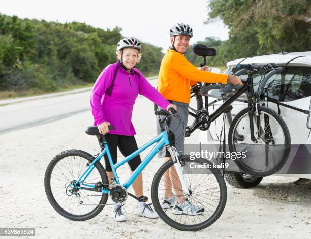 senior couple with mountain bikes - bicycle rack stock pictures, royalty-free photos & images
