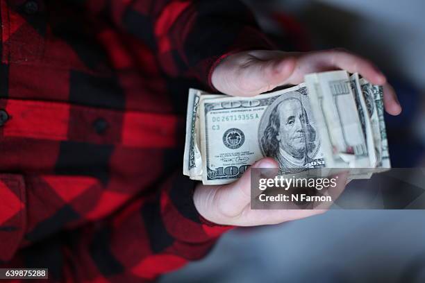 boy holding wad of us dollars - cash in transit stock pictures, royalty-free photos & images