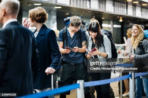 young backpacker couple waiting at check in counter at the airport - lining up imagens e fotografias de stock