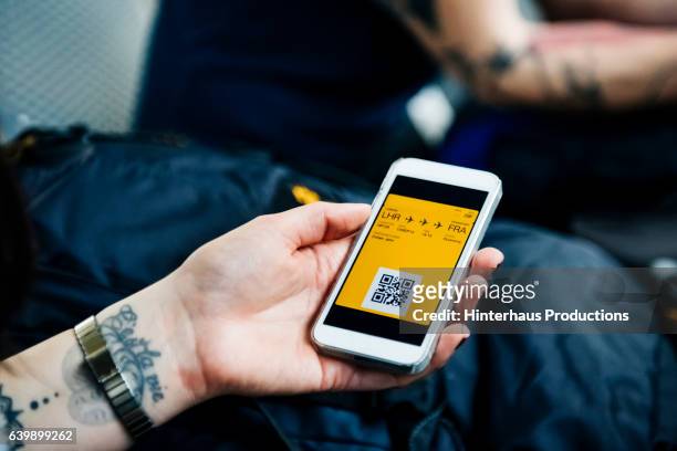 hand of a backpacker showing smart phone with boarding pass - holding mobile phone stock-fotos und bilder