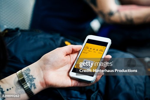 Hand of a backpacker showing smart phone with boarding pass Hand of a backpacker showing smart phone with boarding pass
