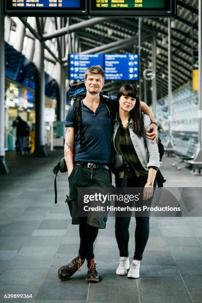 portrait of a young backpacker couple at the airport - rucksacktourist stock-fotos und bilder