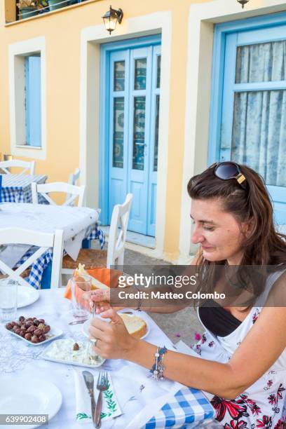 woman eating a typical greek meal. kefalonia, greek islands, greece - greek food stock-fotos und bilder