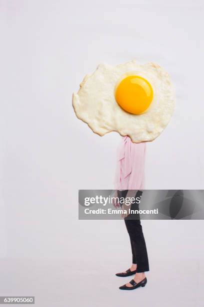 mature woman with head covered by fried egg - sunny side up stock pictures, royalty-free photos & images