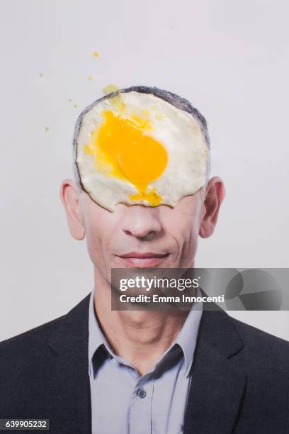 business man forehead covered by fried egg - 40's rumpled business man stockfoto's en -beelden