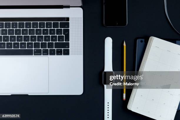 notebook, smartphone, smart watch, calender on black background, high angle view, flat lay, knolling, overhead, top view - desk setup stock pictures, royalty-free photos & images