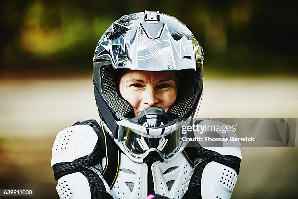 portrait of smiling female motorcyclist in helmet and pads - roupa desportiva de protecção imagens e fotografias de stock