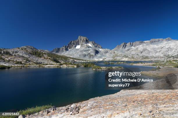 mighty peaks above a beautiful blue alpine lake. - wildnisgebiet ansel adams stock-fotos und bilder