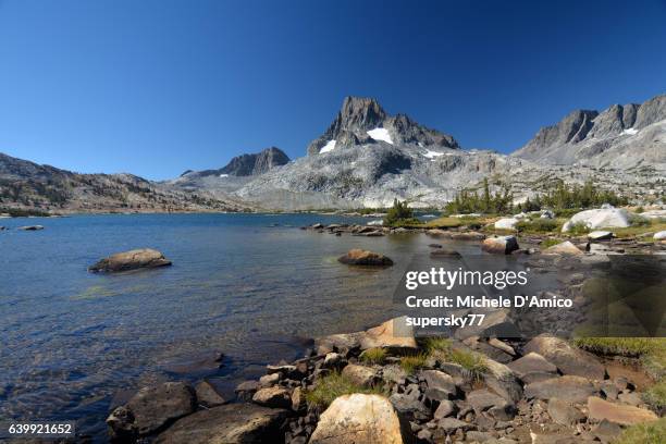 mighty peaks above a beautiful blue alpine lake. - californian sierra nevada stock-fotos und bilder