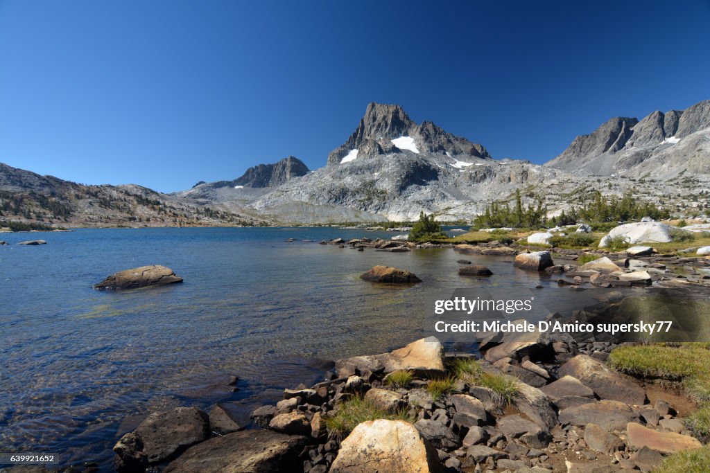 Mighty peaks above a beautiful blue alpine lake.