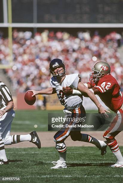 Jim McMahon of the Chicago Bears attempts to pass while being tackled by Ronnie Lott of the San Francisco 49ers during a National Football League...