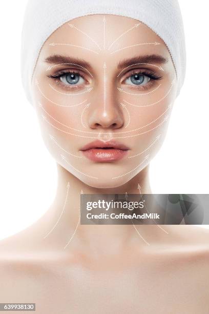 woman's face with arrows as a model of facial massage - tratamento a laser imagens e fotografias de stock